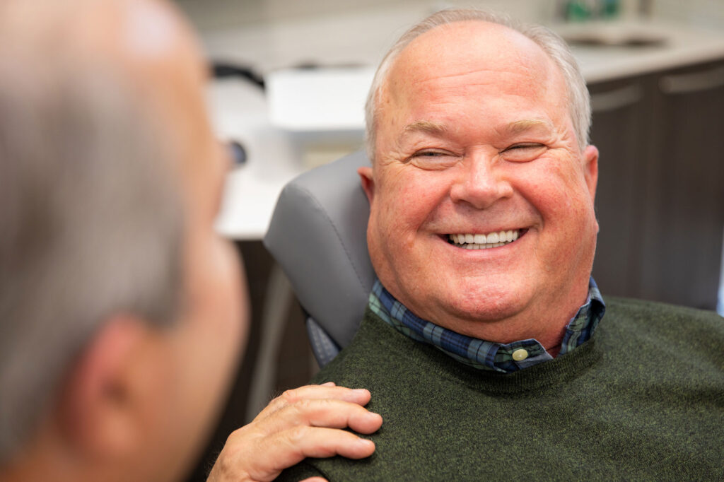 Dr. Eli Jackson Getting Shown A Patient's New Teeth