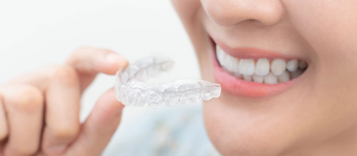 a dental patient holding clear aligners.